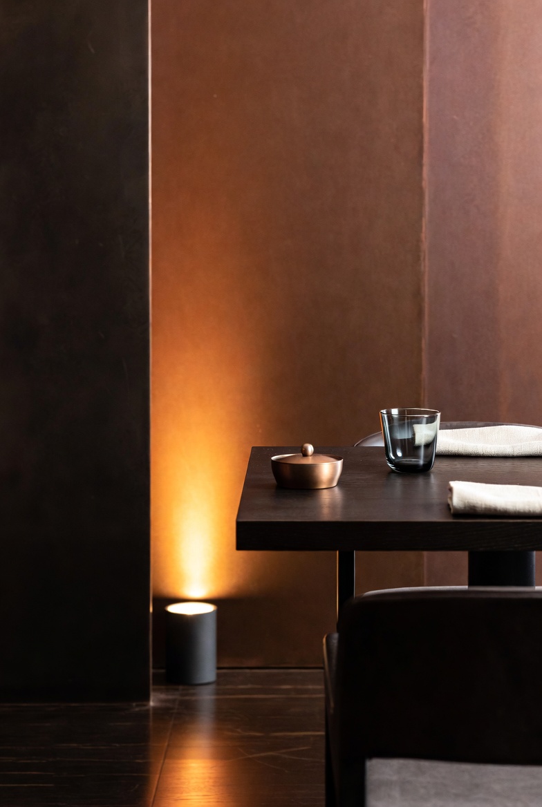 Quiet reservation mood with candlelight, a prepared table, and a softly lit evening room.